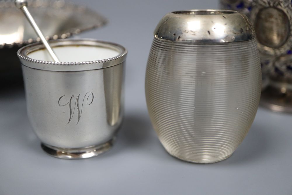 An Edwardian silver sugar basket, George V silver bon-bon dish, silver mounted match strike and a mug salt and spoon (4)